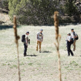 group of hikers in the backcountry of Fishers Peak State park with plant stalks in the foreground.