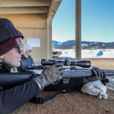 Multiple shooting range participants look down the range 