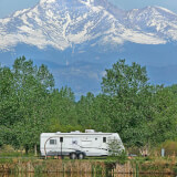 Camper with trees and snowy Longs Peak in background