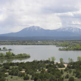 A lake with an irregular shape spans across the landscape with mountains on the horizon.